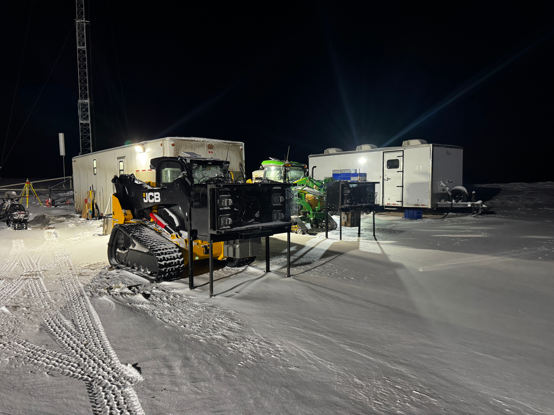 Field office staging site at night with equipment parked