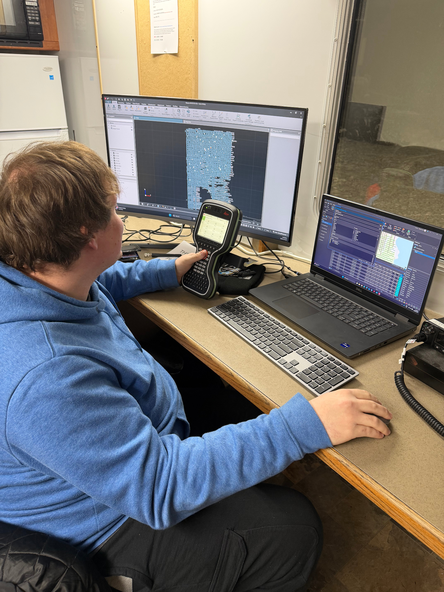 GNSS technician processing data in field office