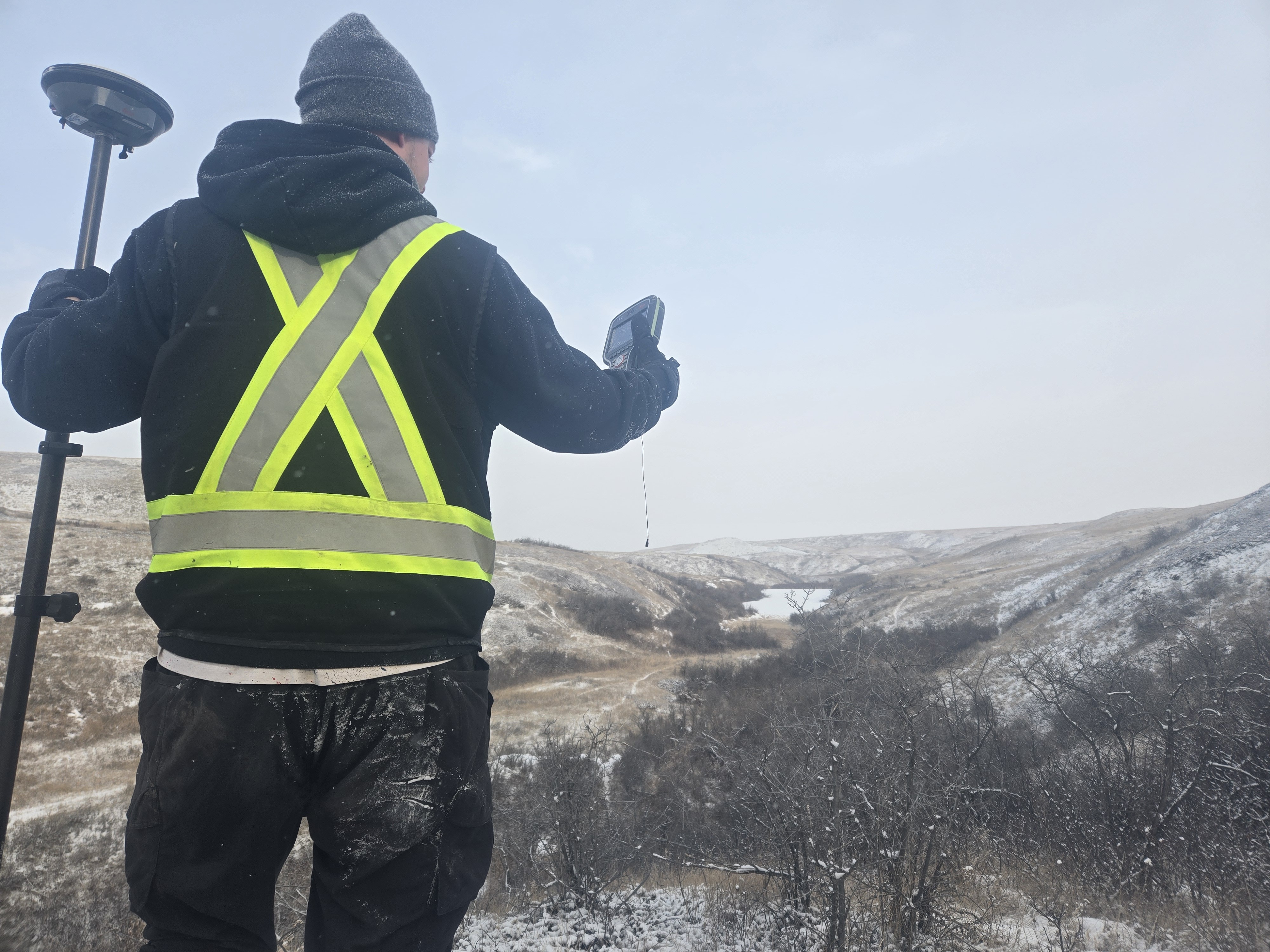 Surveyor on a snowy hillside with controller