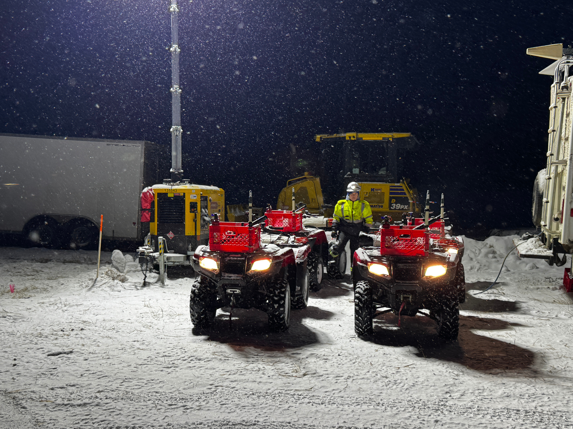 Quads staged in a snowstorm before dawn for GNSS survey mobilization
