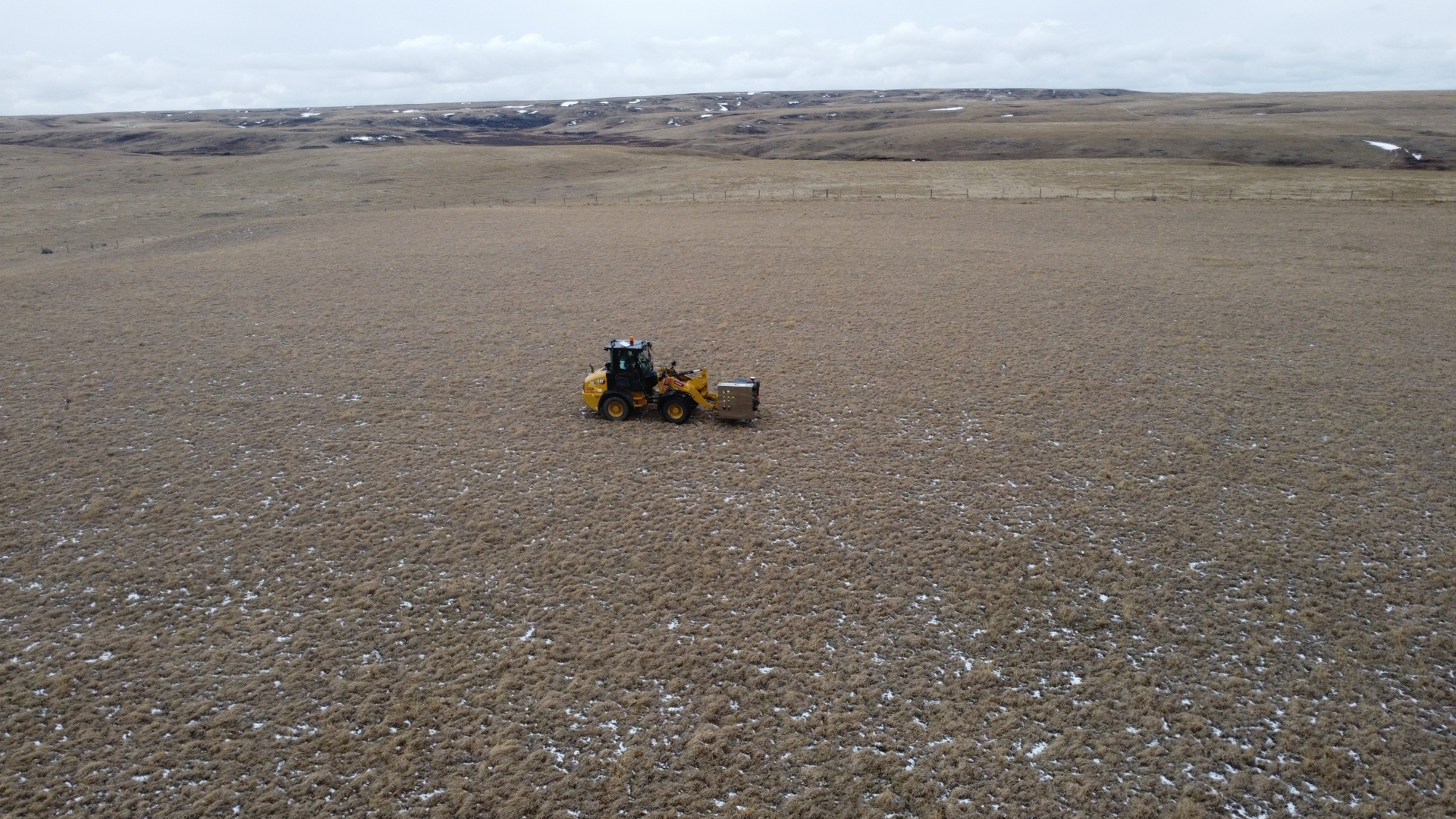 Aerial view of vibroseis trucks lined up on a seismic source line