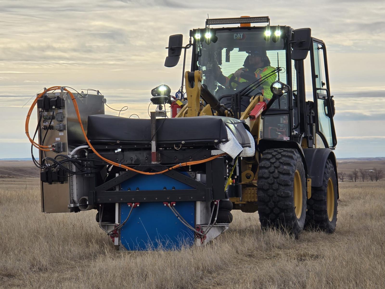 Close-up of a low-impact vibroseis source unit on a compact wheel loader